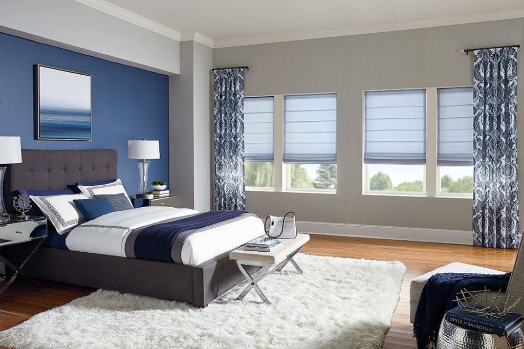 Hobbled roman shades offer soft texture while bold side panels draw attention to natural light with Comfortex Window Fashions.